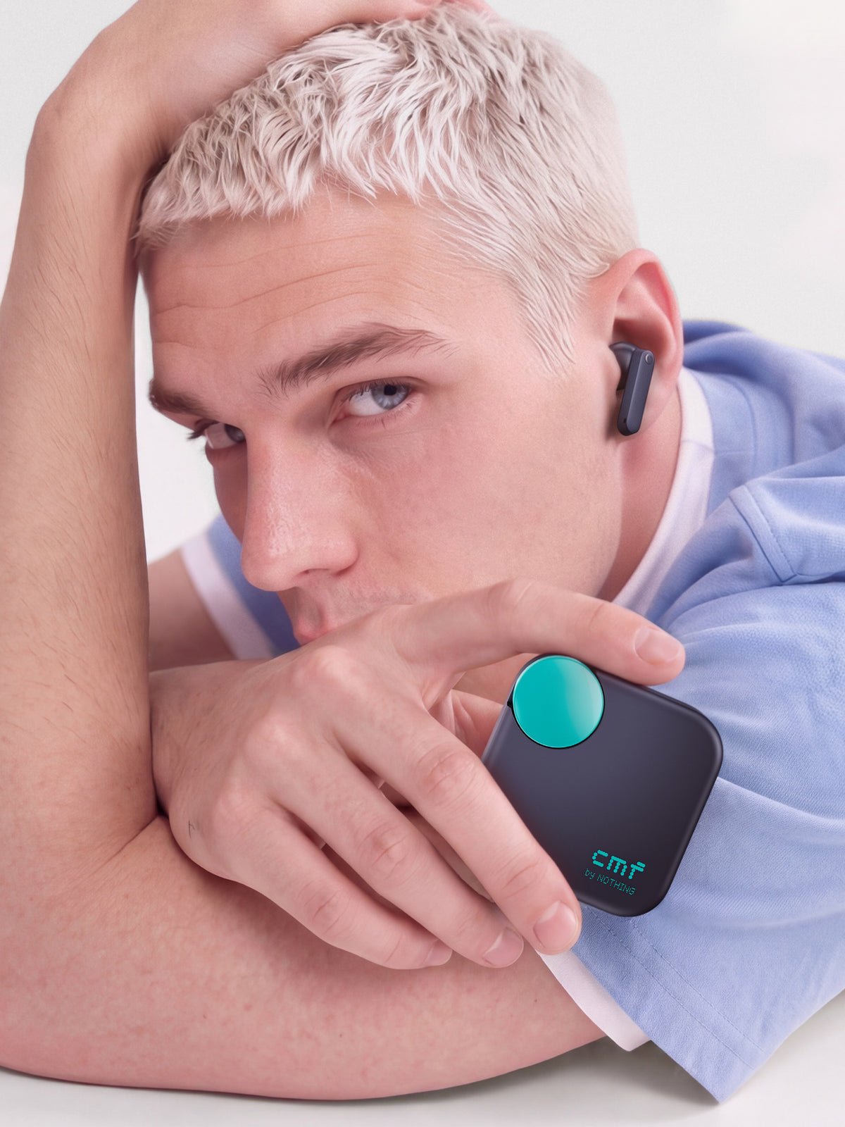 A listener wearing CMF Buds Neo and holding its charging case