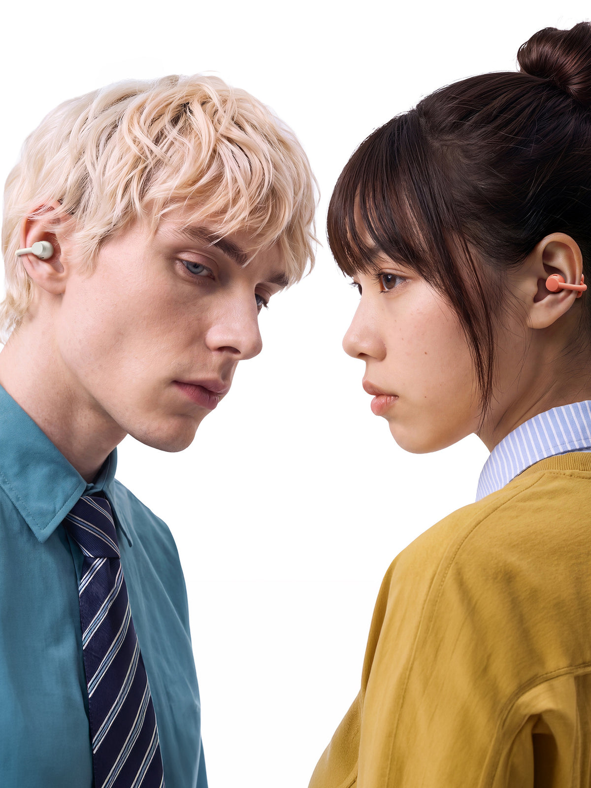 Two people facing one another wearing clip earbuds