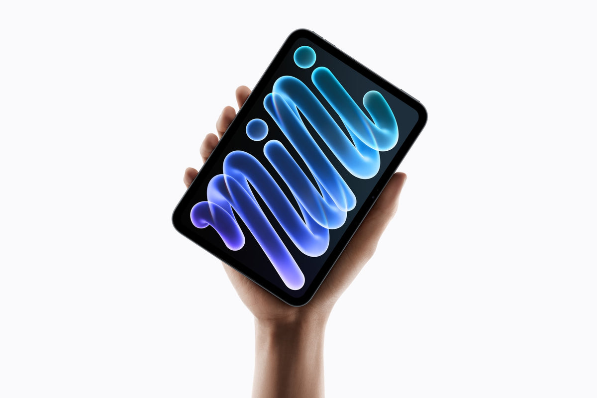A hand holding an iPad mini with blue and purple artwork on its screen.
