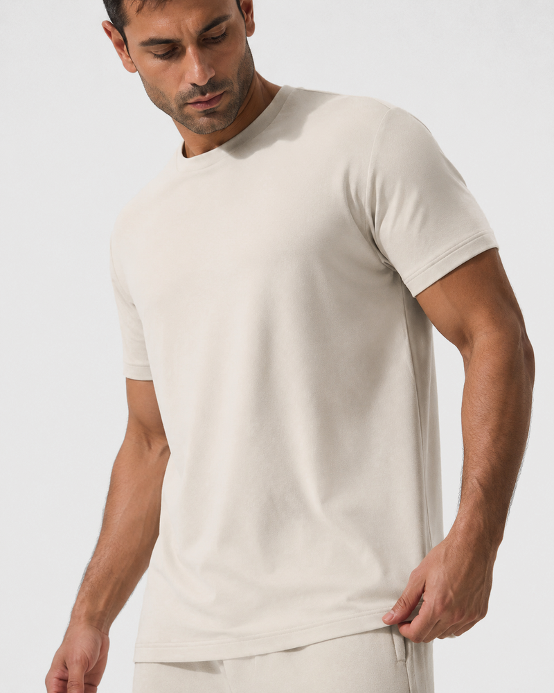 Close view of the Ivory Relaxed Tee, with a hand holding the hem.