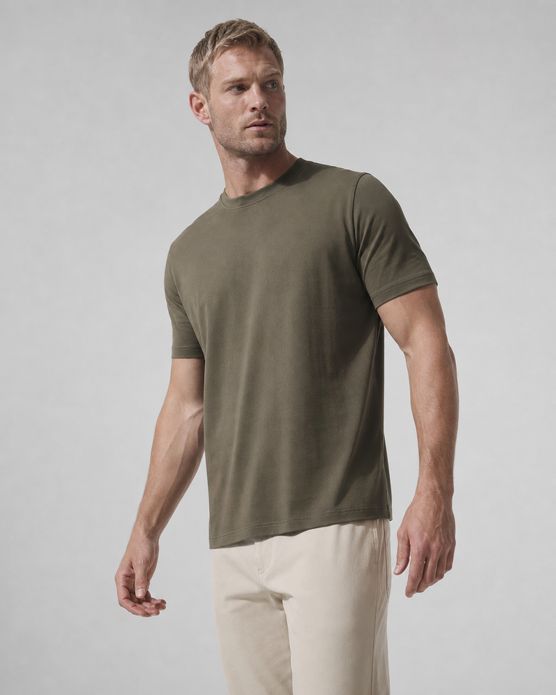 Three-quarter view of the Pine Relaxed Tee with light trousers.