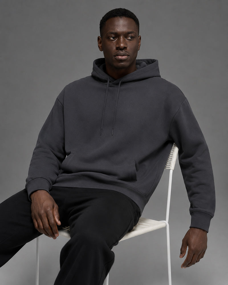 Model seated in TexTale hoodie in Charcoal