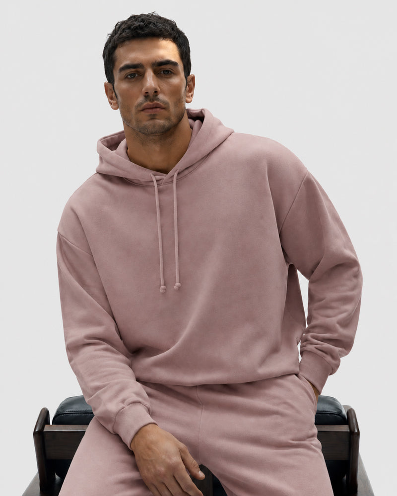 Model seated in the TexTale Rain-Repel Hoodie in Pink Gray