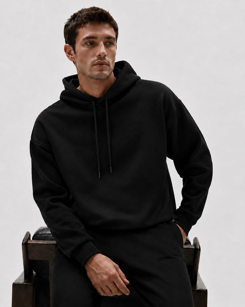 Model seated in the TexTale Rain-Repel Hoodie in Black